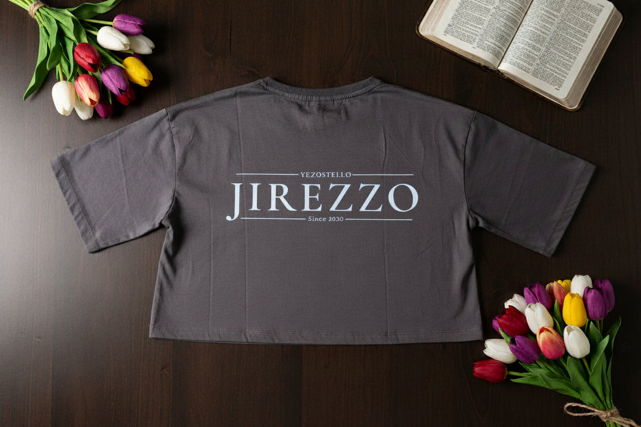 Gray shirt with 'Jirezzo' branding on a wooden surface with tulips and an open book.