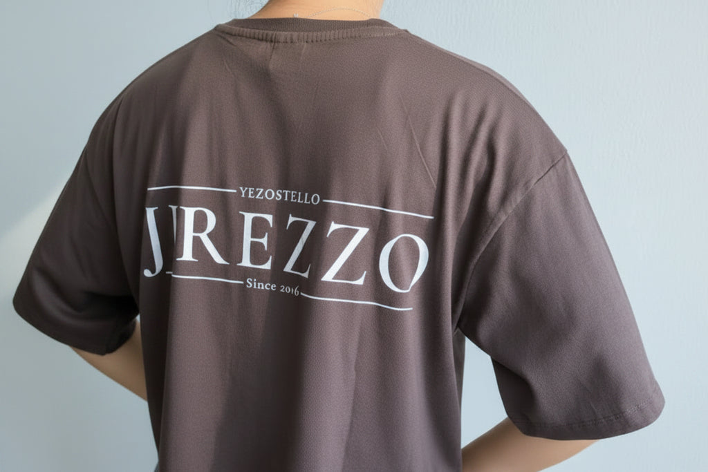 Brown t-shirt with 'YREZZO' branding on the back against a light gray background