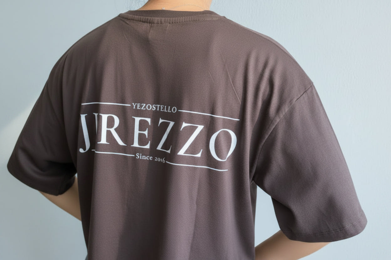 Brown t-shirt with 'YREZZO' branding on the back against a light gray background