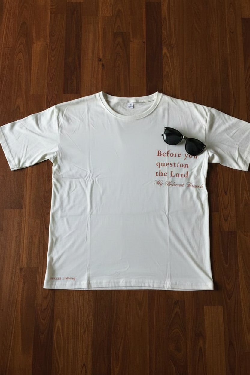 White t-shirt with text and sunglasses graphic on a wooden surface